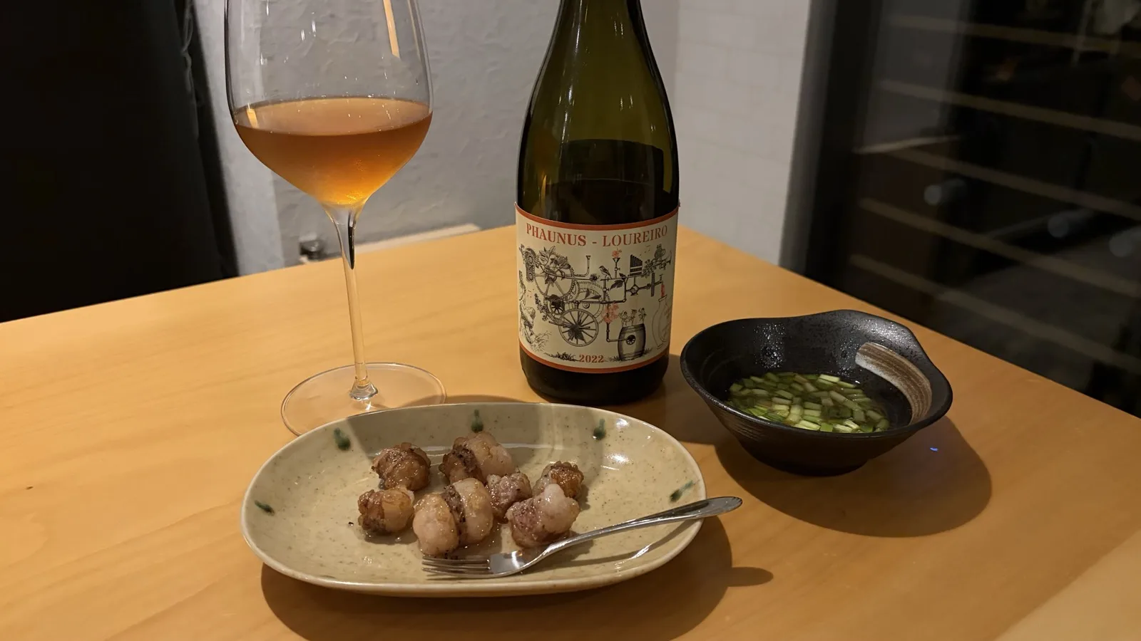 オレンジワインのグラスとホタテの焼き物、小鉢のおつまみ