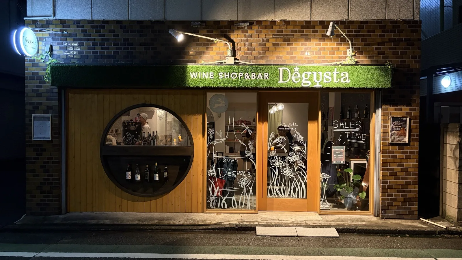 緑の看板、丸窓、木の扉が目印のDegusta外観